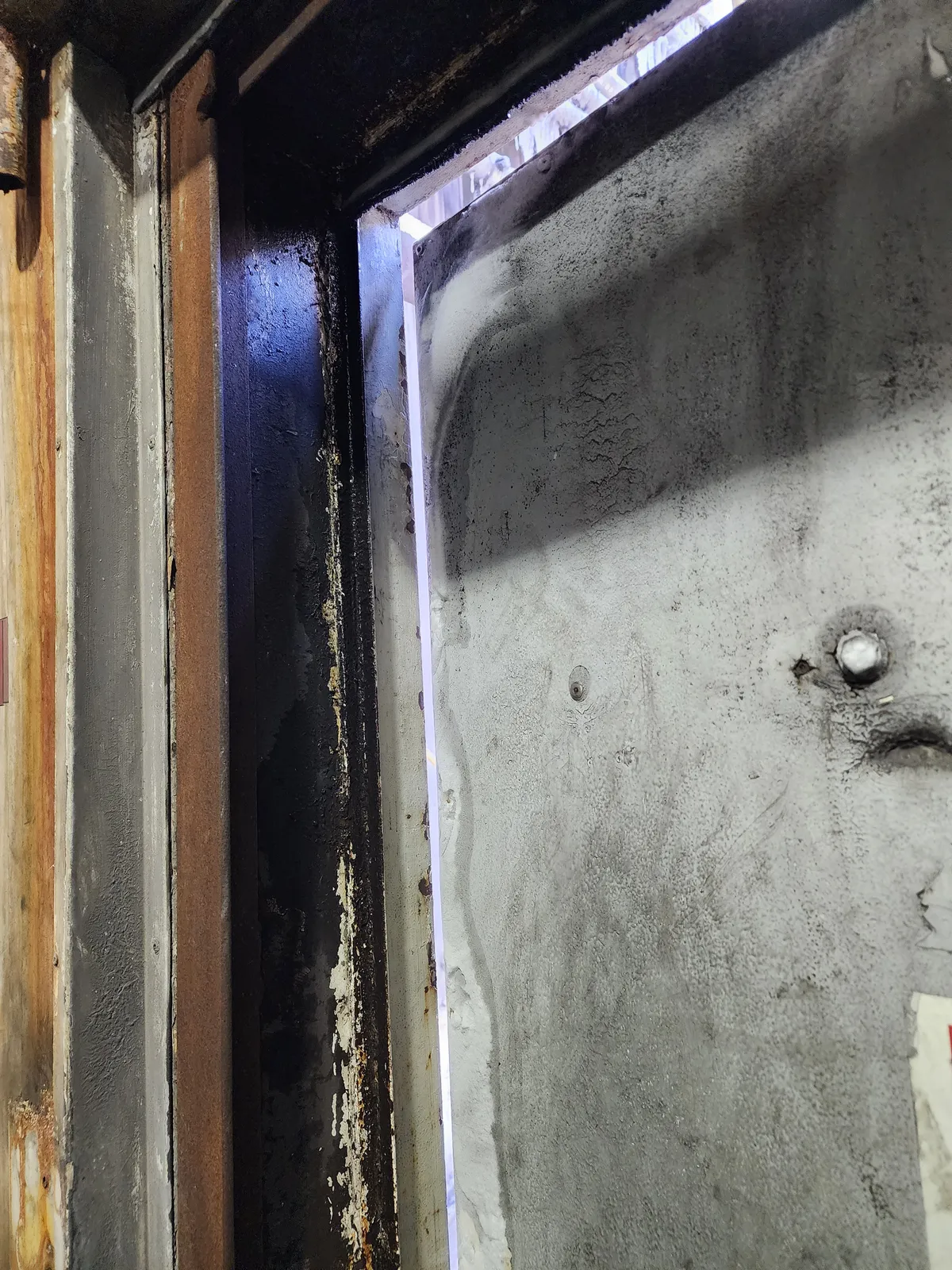 Light showing through a narrow opening beside a door frame and threshold